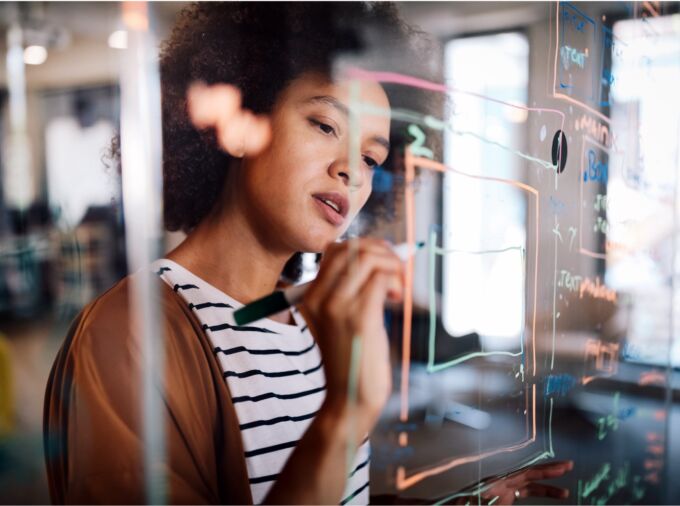 researcher writing ideas on glass